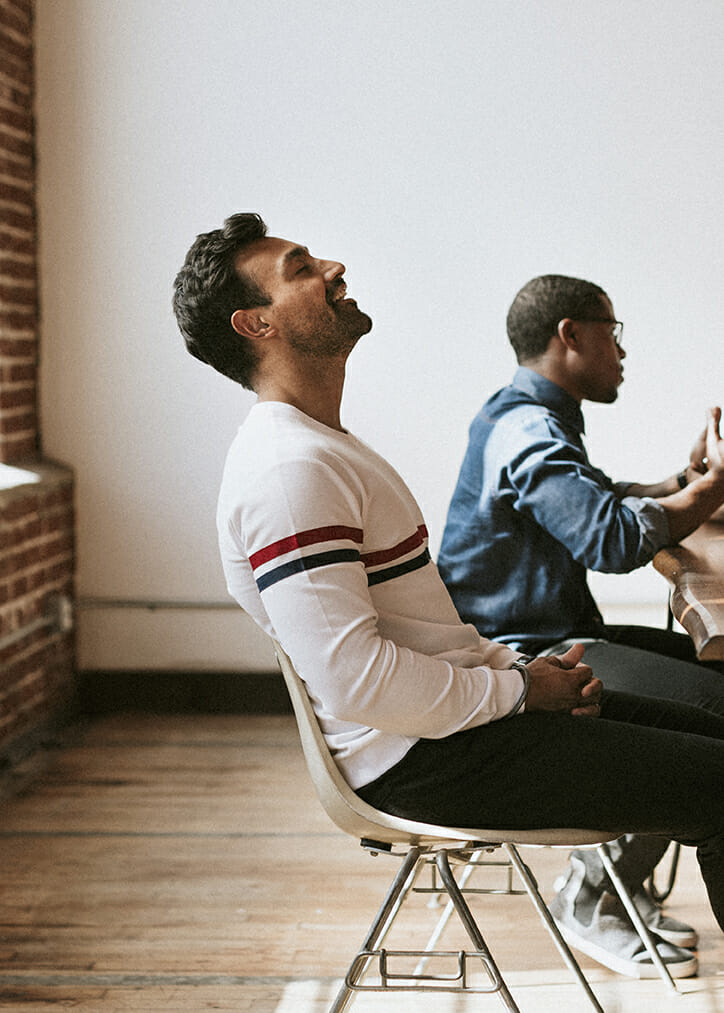 Cheerful man sitting with his eyes closed in a meeting